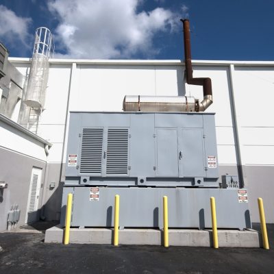 A diesel generator standby unit on the exterior of a building